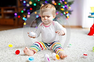 Adorable cute beautiful little baby girl playing with educational colorful shape sorter toy