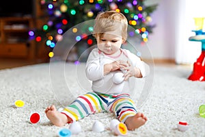 Adorable cute beautiful little baby girl playing with educational toys at home or nursery. Happy healthy child having