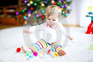 Adorable cute beautiful little baby girl playing with educational toys at home or nursery. Happy healthy child having