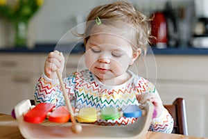 Adorable cute beautiful little baby girl playing with educational wooden music toy at home. Happy excited toddler child