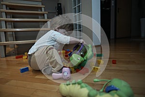 Adorable cute beautiful little baby girl playing with toys at home