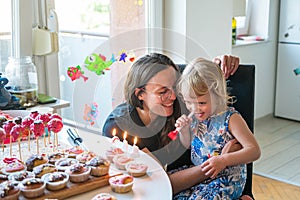 Adorable cute blonde girl celebrating her third birthday.