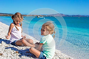 Adorable cute girls have fun on white beach during