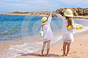 Adorable cute girls have fun on white beach during