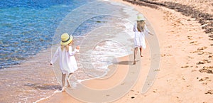 Adorable cute girls have fun on white beach during