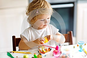 Adorable cute little toddler girl with colorful clay. Healthy baby playing and creating toys from play dough. Small kid