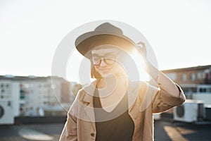 Adorable cute woman in fedora hat at sunset