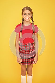 Adorable cutie. Cute little girl charming smile on yellow background. Happy small girl wearing red clothes. Girl with