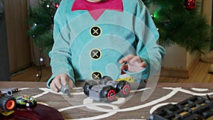 Adorable elf kid, in Santa Claus workshop fixing toys for kids