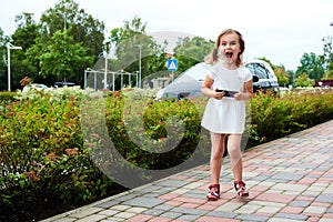 Adorable expressive little girl with a smartphone