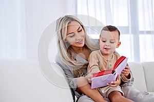adorable family young mother babysitter hold read book relax embrace cute little boy