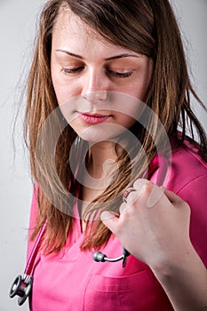 Adorable, female doctor looking at her stethoscope.