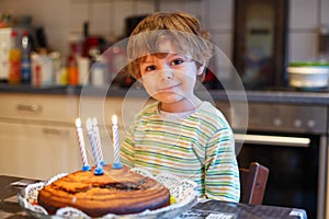 Adorable four year old boy celebrating his birthday and blowing