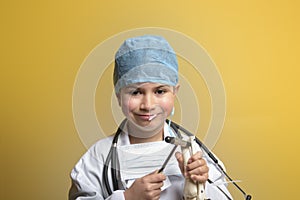 Adorable future doctor 7 years old boy isolated on yellow.