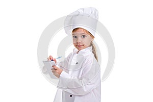 Adorable girl chef white uniform isolated on white background. Writing the notes, looking straight to the camera