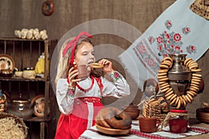 Adorable girl drinking tea from samovar