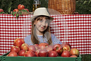 Adorable Girl in Hat With Freshly Harvested Red Apples