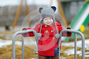 Adorable girl having fun on a playgroud on spring photo