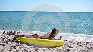 Adorable girl on inflatable air mattress on the beach