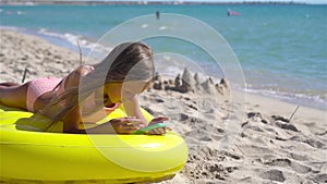 Adorable girl on inflatable air mattress on the beach