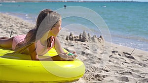 Adorable girl on inflatable air mattress on the beach