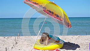 Adorable girl on inflatable air mattress on the beach