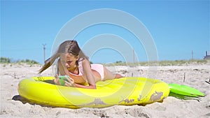 Adorable girl on inflatable air mattress on the beach