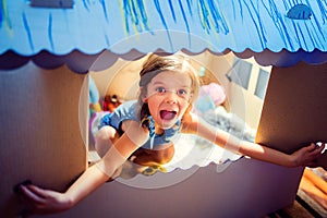 Adorable girl inside of carton playhouse