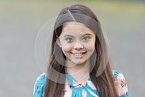 Adorable girl long hair smiling face urban background outdoors, beautiful smile concept