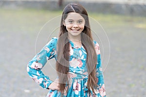 Adorable girl long hair smiling face urban background outdoors, childrens day concept