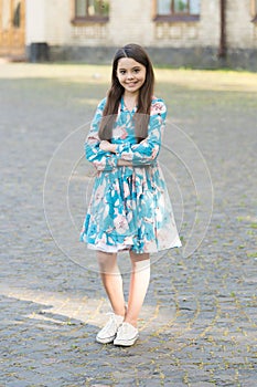 Adorable girl long hair smiling face urban background outdoors, confident posture concept