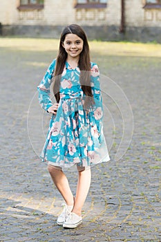 Adorable girl long hair smiling face urban background outdoors, stylish outfit concept