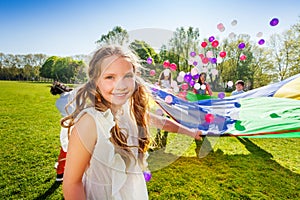 Adorable girl playing parachute with her friends