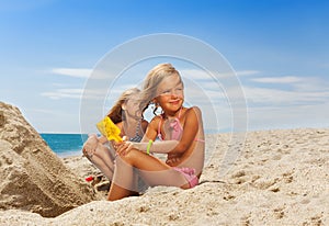 Adorable girl playing with sand at the beach