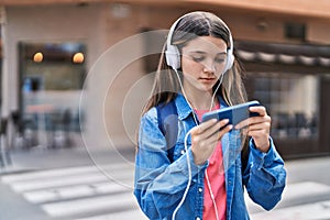 Adorable girl playing video game at street