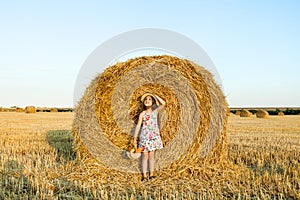Adorable girl in rye field on sunset with a basket of bread