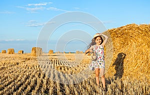 Adorable girl in rye field on sunset with a basket of bread