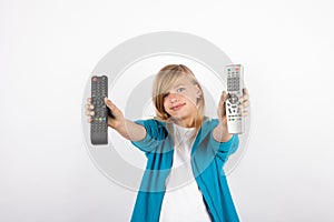 Adorable girl showing TV remote controls.