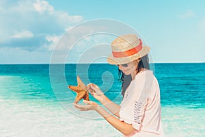 Adorable girl with starfish on the beach