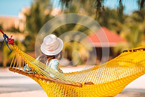 Adorable girl on tropical vacation relaxing in hammock