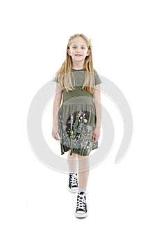 Adorable girl walking. Full length studio shot