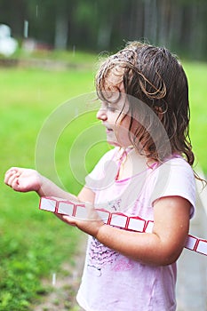 Adorable girl walking with toy at rainy day