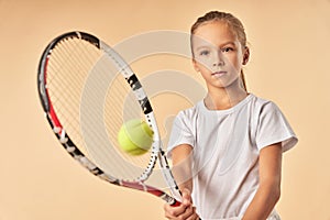 Adorable girl in white shirt playing tennis