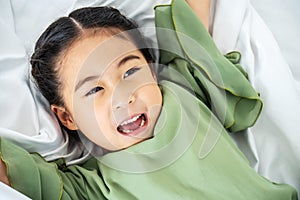 Adorable happy asian little kid girl after sleeping in her white bed  Funny happy child playing and smiling