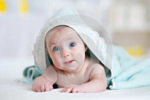 Adorable happy baby under towel indoor