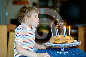 Adorable happy blond little kid boy celebrating his birthday.