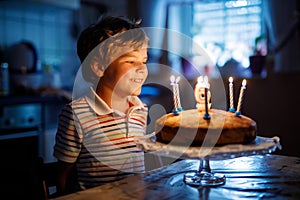 Adorable happy blond little kid boy celebrating his birthday.