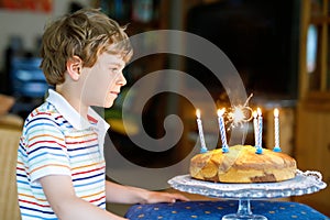 Adorable happy blond little kid boy celebrating his birthday.