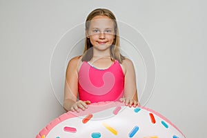 Adorable happy child girl with inflatable ring swimming float closeup. Summer, vacation and leisure activity concept