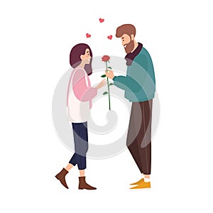 Adorable happy couple in love on romantic date. Cute smiling boy giving rose flower to girl. Young man and woman met